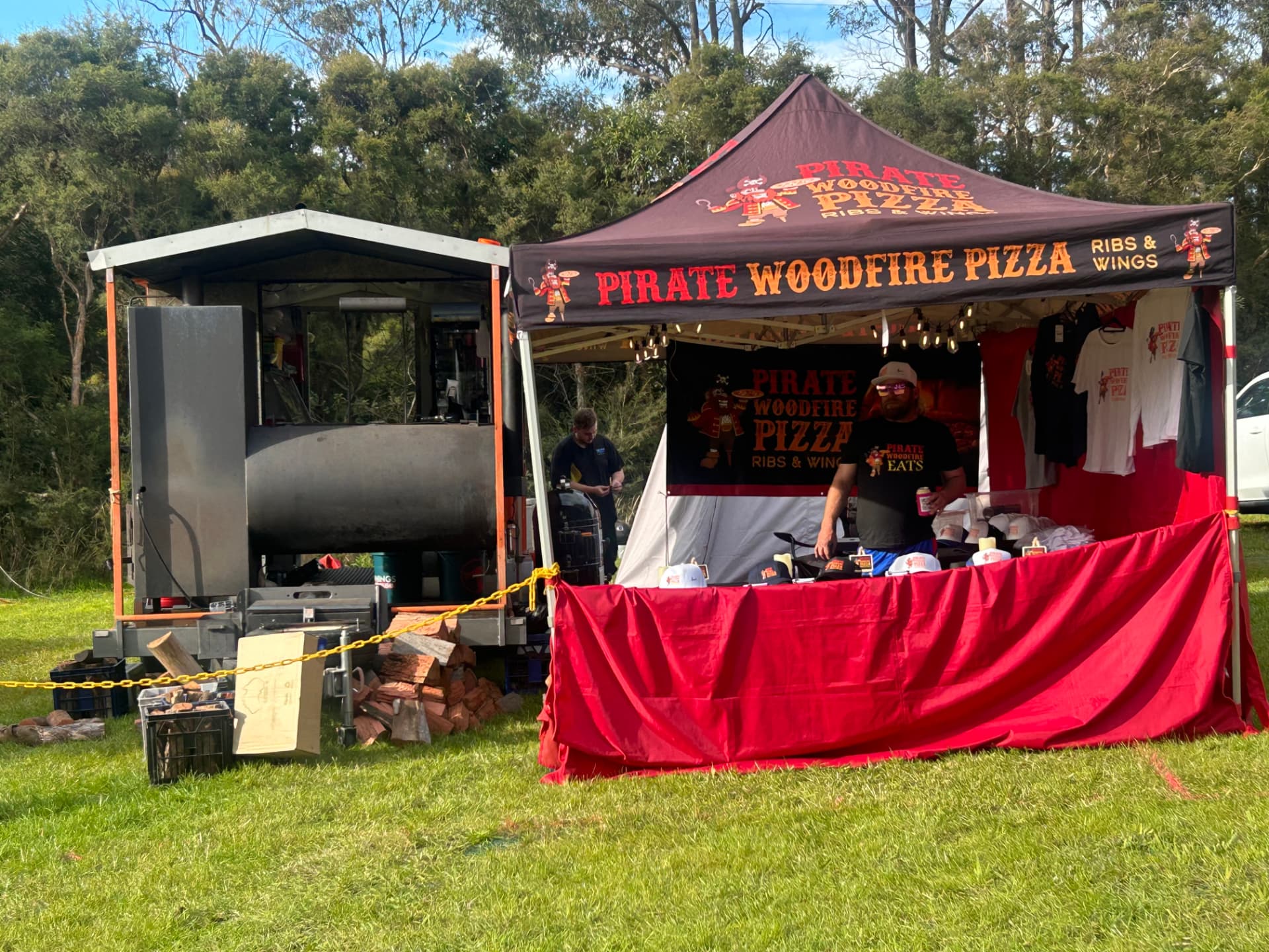 Pirate Woodfire Eats stall and smoker set up at an outdoor event